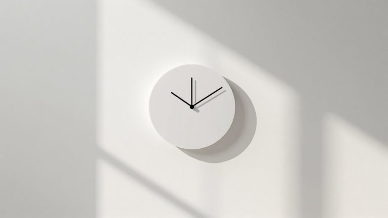 A plain white wall clock casting a hard shadow, the question of how often to update a website.