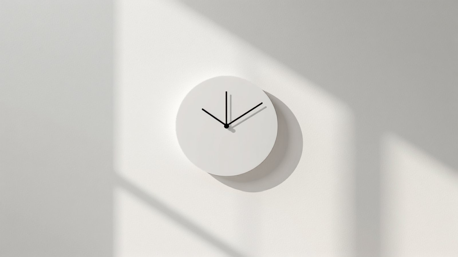 A plain white wall clock casting a hard shadow, the question of how often to update a website.
